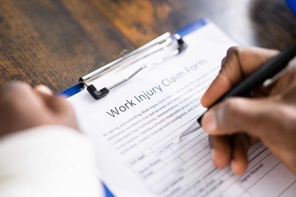 Injured worker completing a workplace injury claim form in Dallas, Texas